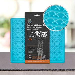 PLATINUM Podloga LickiMat® - BUDDY X Large za pse je prikazana v modri barvi z embalažo, na kateri so poudarjene prednosti za lajšanje stresa in dolgočasja ter bližnji posnetek teksturiranega križnega vzorca za počasno hranjenje psa.
